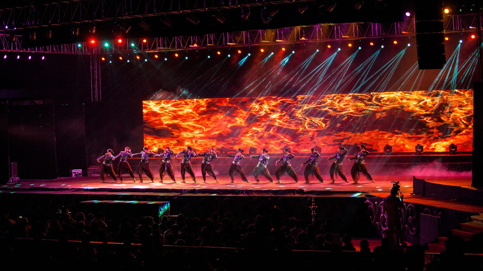 Abhijnaa — dancers in line before a wall of fire